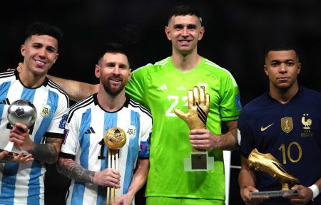 Enzo Fernandez, Messi, Dibu Martinez, and Mbappé, raising their individual trophies in the 2022 World Cup
